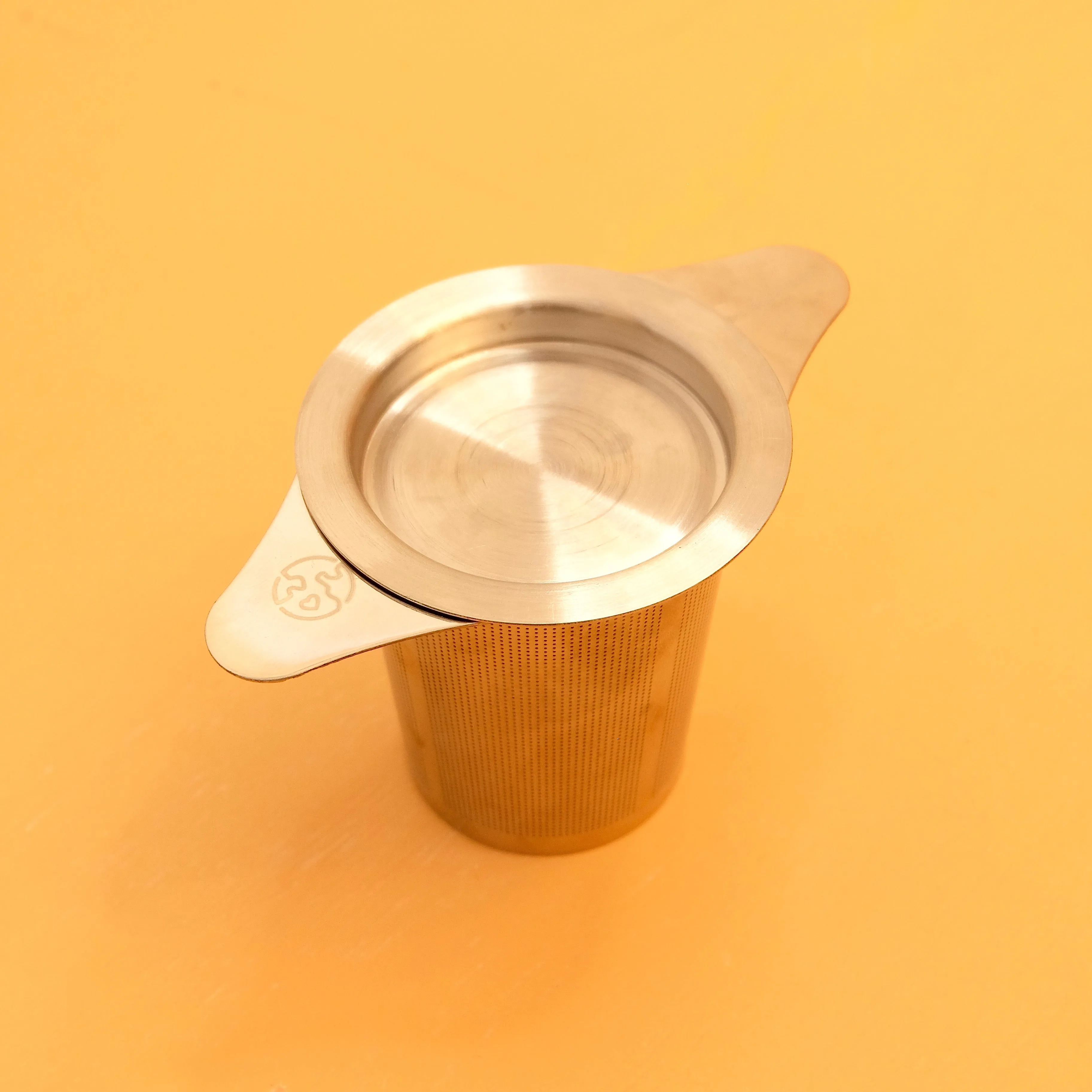 STAINLESS STEEL TEA STEEPER STRAINER SITS ON MUG